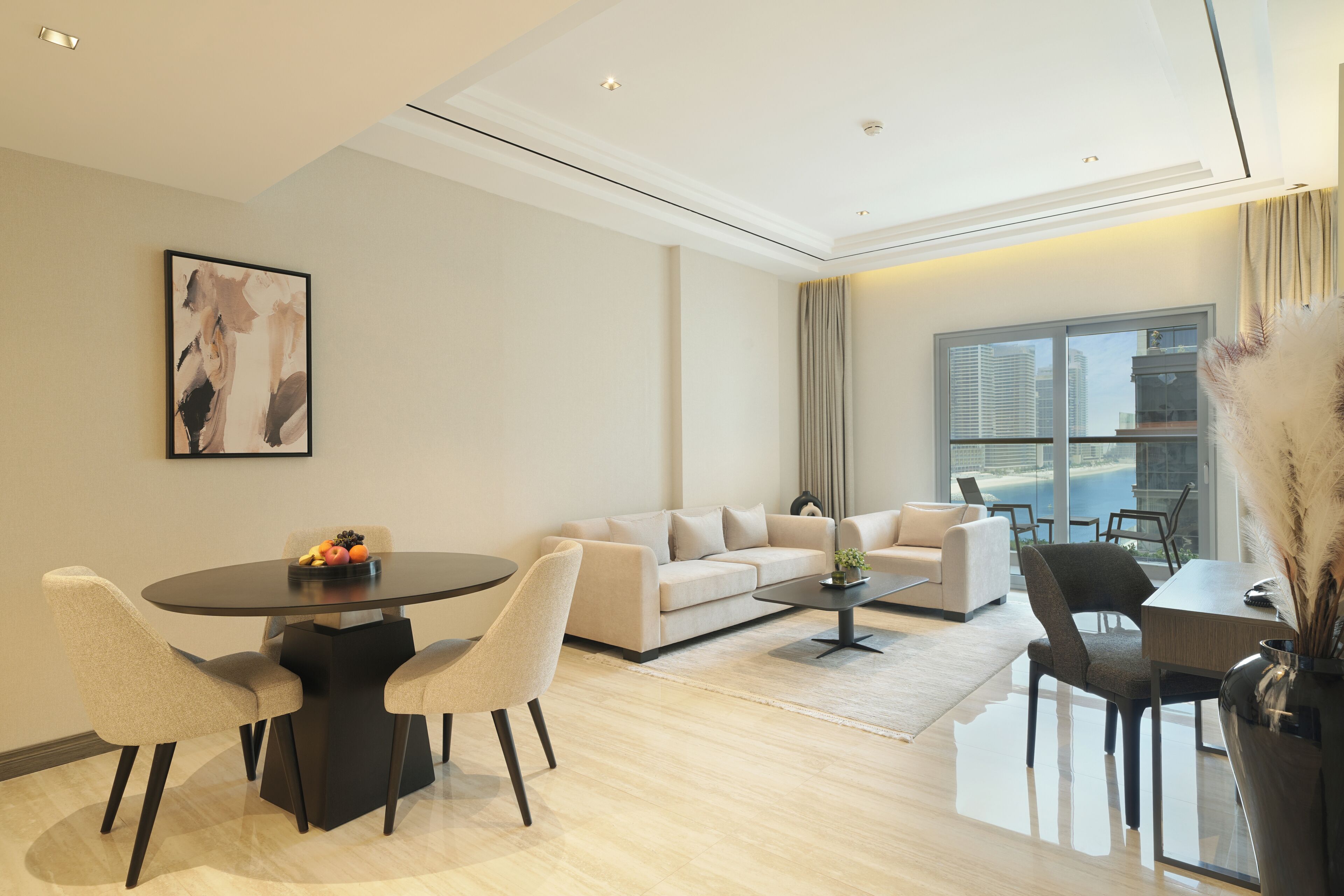 A modern living room with a round dining table, two sofas, and a coffee table.