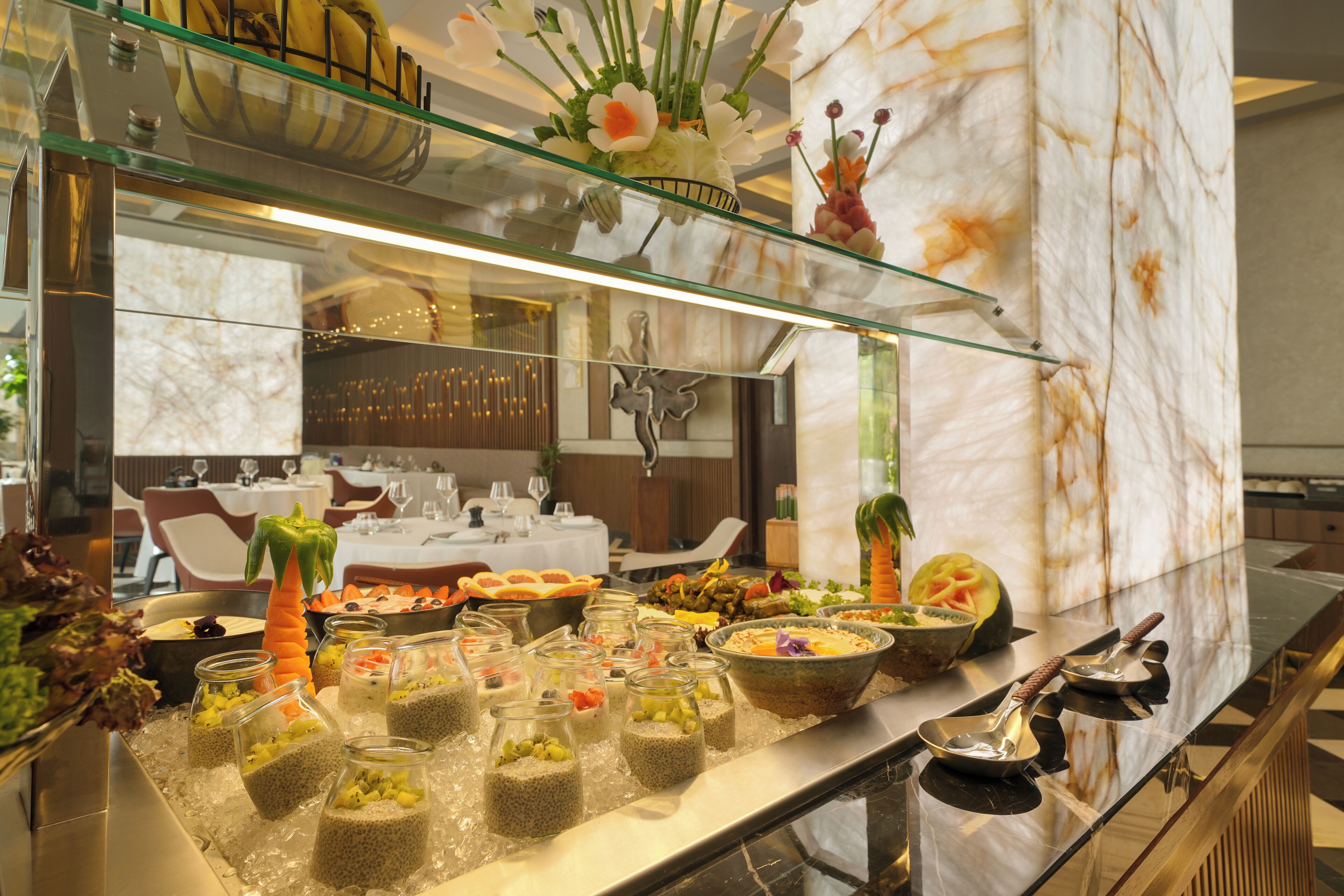 Un buffet con diversi cibi e una vetrina che espone fiori.