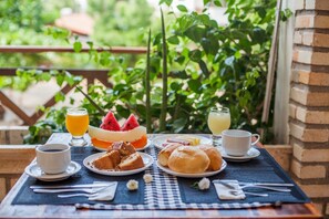 Une table de petit-déjeuner avec des assiettes remplies de nourriture, des boissons et une tasse de café.