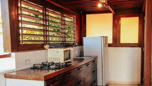 Una cocina equipada con microondas, estufa y refrigerador.