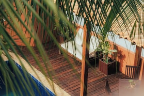 A wooden deck with potted plants and a chair. - Pipa Panorama Flats&Apartamentos (Tibau do Sul)