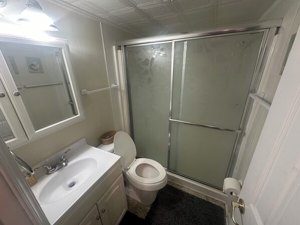 Une salle de bain avec un lavabo blanc, un miroir et des toilettes.