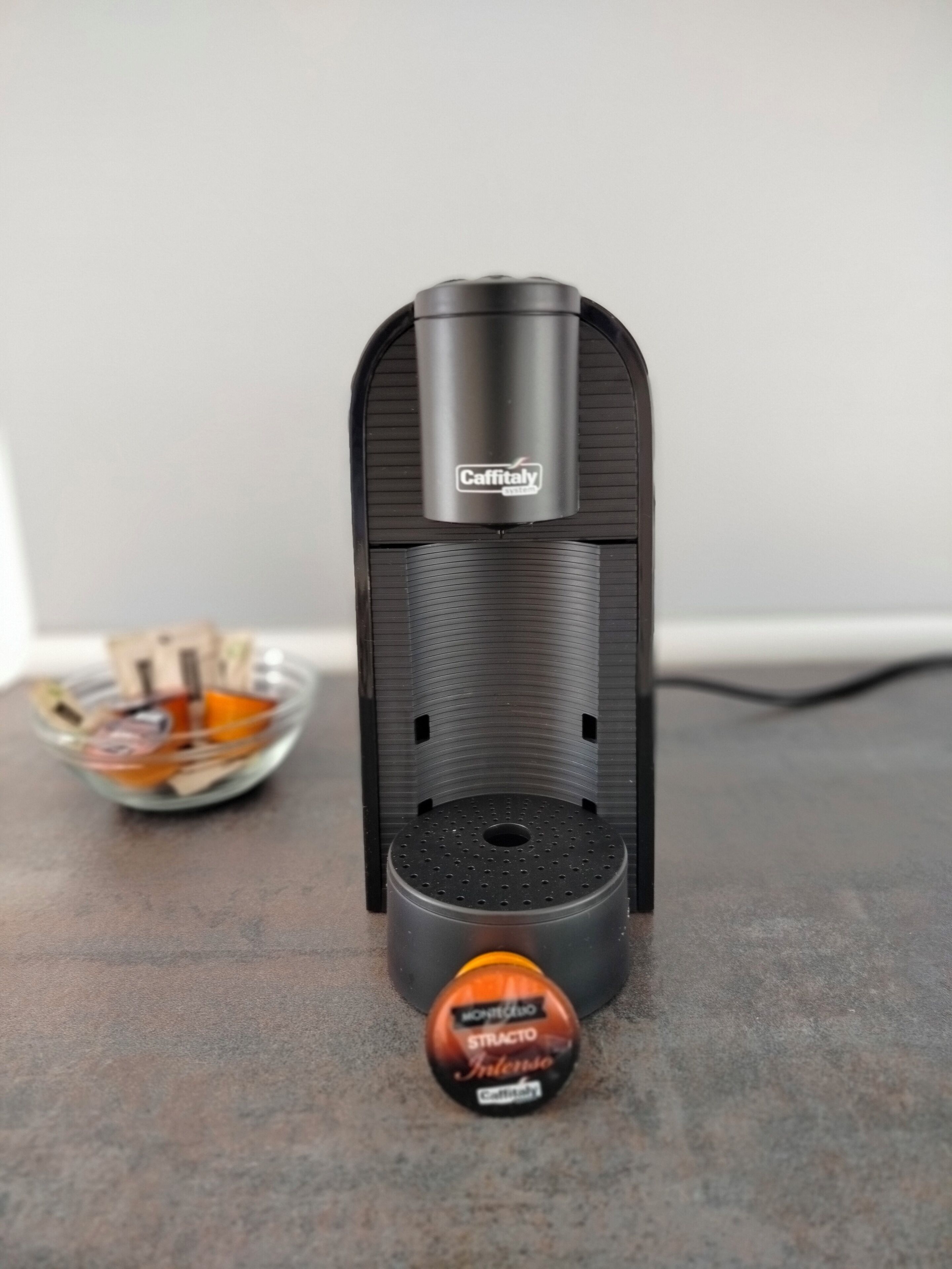 Une machine à expresso Caffitaly avec une dosette de café posée sur le comptoir.