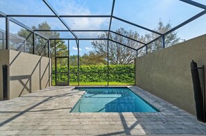 A swimming pool with a glass enclosure, surrounded by a paved area and a hedge. - New Luxury Getaway Themed Bedrooms (Davenport)