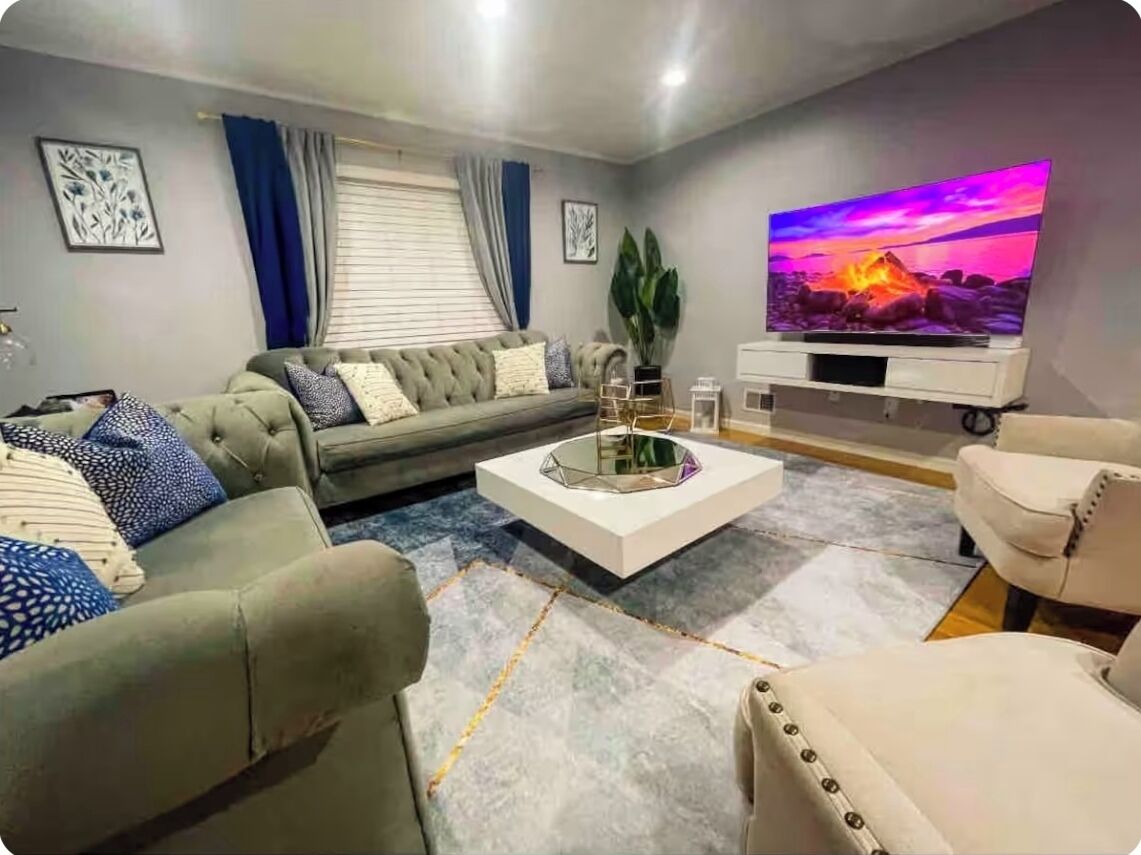 Ein modernes Wohnzimmer mit einer Couch, einem Sessel und einem Couchtisch.