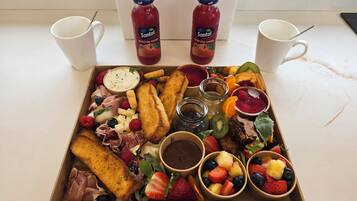 A breakfast tray with toast, fruit, cheese, and jam.