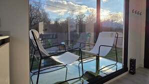 Une chambre moderne dotée d’une grande fenêtre en verre donnant sur un jardin.