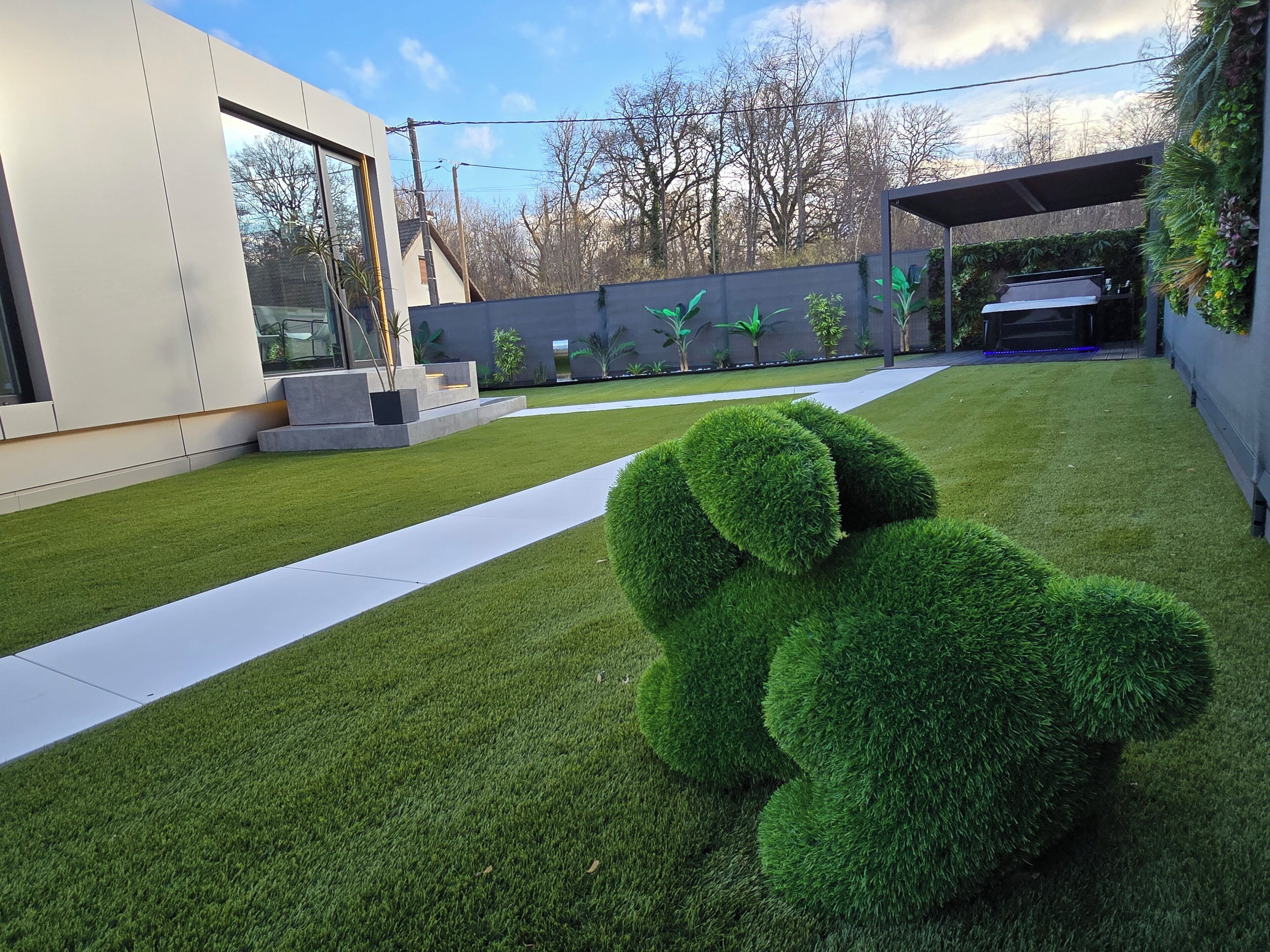 Een modern huis met een verzorgd gazon, een groot raam en een barbecueplek.