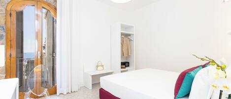 Ein Schlafzimmer mit Bett, Kleiderschrank, Schreibtisch und Stuhl.