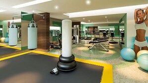 Een moderne sportschool met trainingsapparatuur, een bokszak en een yogamat.