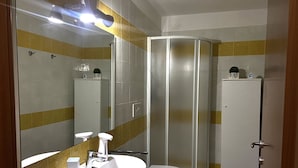 A bathroom with a sink, two toilets, a shower, and a mirror. - Oasis La Verde in the Countryside (Follonica)