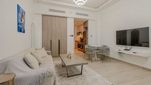 A modern living room with a sofa, coffee table, TV, and dining area. - Me Do Re JLT 1408 in Dubai (Dubai)