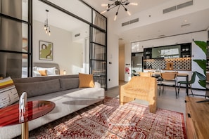 Ein modernes Wohnzimmer mit einer Couch, einem Couchtisch und einem gemusterten Teppich.