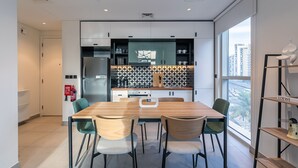 A modern kitchen with a central island, built-in appliances, and a view of the city. - Socio Tower 1 206 Dubai Hills (Dubai)