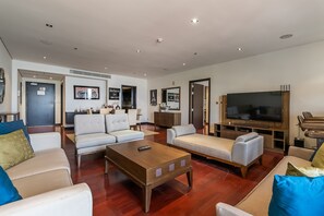A modern living room with a large flat-screen TV, leather sofas, a wooden coffee table, and a minimalist decor. - Anantara South 309 in Dubai (Dubai)