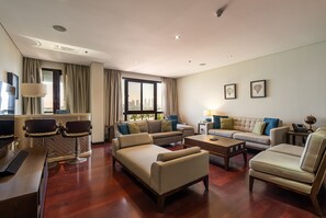 A modern living room with a sofa, armchairs, a coffee table, and a TV. - Anantara South 309 in Dubai (Dubai)