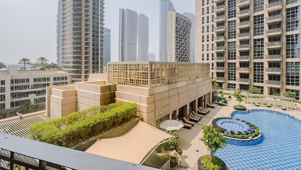 A rooftop pool area with lounge chairs and a circular hot tub, surrounded by high-rise buildings. - Standpoint 706 in Dubai (Dubai)
