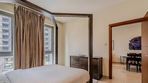 A hotel room with a large bed, a desk, a chair, and a view of the city through the window. - Standpoint 706 in Dubai (Dubai)