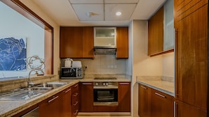 A modern kitchen with wooden cabinets, stainless steel appliances, and a granite countertop. - Standpoint 706 in Dubai (Dubai)