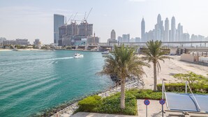 A coastal cityscape with a marina, palm trees, and modern high-rise buildings. - Azure Residences 117 Premium 2bdr Palm (Dubai)