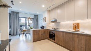 A modern kitchen with wooden cabinets, a built-in oven, and a large window. - Tilal AL Ghaf 245 in Dubai (Dubai)