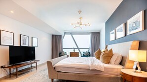 Un dormitorio moderno con una cama grande, un televisor y vistas al exterior.