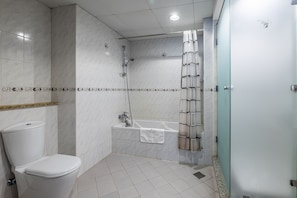 Ein modernes Badezimmer mit Toilette, Waschbecken, Badewanne und Dusche.