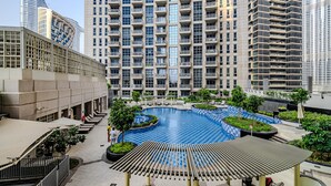A modern residential building with a central courtyard featuring a swimming pool, surrounded by balconies and greenery. - Standpoint Tower 1 606 (Dubai)