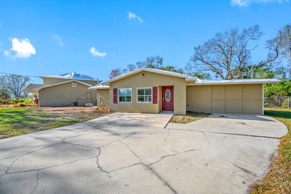 A two-story house with a garage, a front yard, and a driveway. - The Perfect Family Retreat w Pool and Games (Tampa)