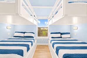 A room with bunk beds, a window with a view, and wall-mounted lights. - Beach View | Hot Tub | Sleeps 14 + Hammock (Crystal Beach)