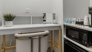 A modern kitchen with a white countertop, a bar stool, a microwave, and a coffee machine. - Bay Ridge ApartHotel (Brooklyn)