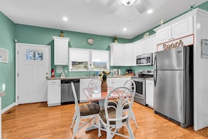Enjoy meals in this kitchen with a dining table and chairs, featuring a window with a view.