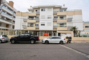 A multi-story residential building with balconies, a parking area, and a visible entrance to a building labeled 'DOM VIRGILIO 272'. - Residencial Dom Virgílio (Florianópolis)