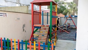 A playground with a climbing structure and slides. - Residencial Dom Virgílio (Florianópolis)