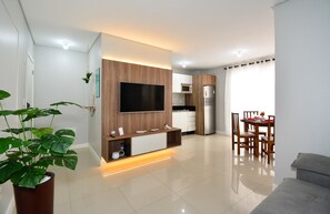 Una cocina moderna con microondas integrado, refrigerador y comedor con mesa y sillas.