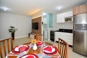 A modern kitchen with a built-in oven, microwave, and refrigerator. - Residencial Dom Virgílio (Florianópolis)