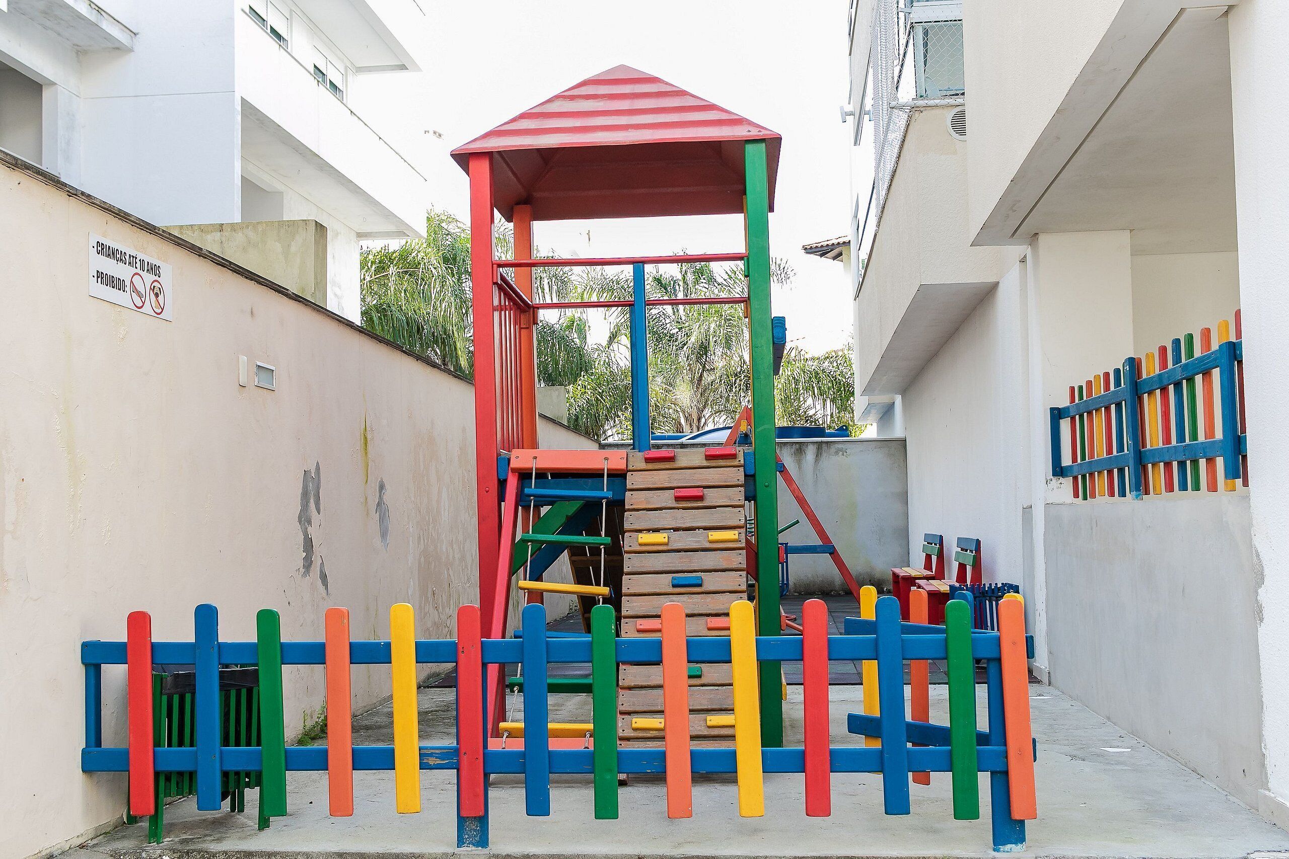 A playground with a climbing structure and a red-roofed shelter.