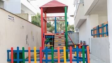 A playground with a climbing structure and a red-roofed shelter.