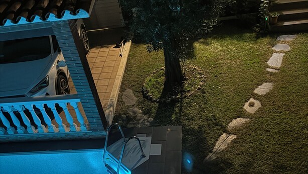 Una piscina con un borde de baldosas y una pequeña cascada.