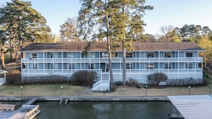 A two-story building with a dock and a small boat. - Deluxe Studio Suite, 2 Queen Beds, Lake View, Ground Floor (Hot Springs)