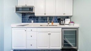 A kitchen with white cabinets, a microwave, a sink, and a refrigerator. - Deluxe Studio Suite, 2 Queen Beds, Lake View, Ground Floor (Hot Springs)