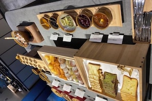 A display of various food items, including jars of preserves and trays of sandwiches.