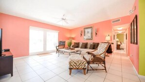 A living room with a sofa, armchairs, a coffee table, and a television. - Holly s Hideout in Islamorada (Tavernier)