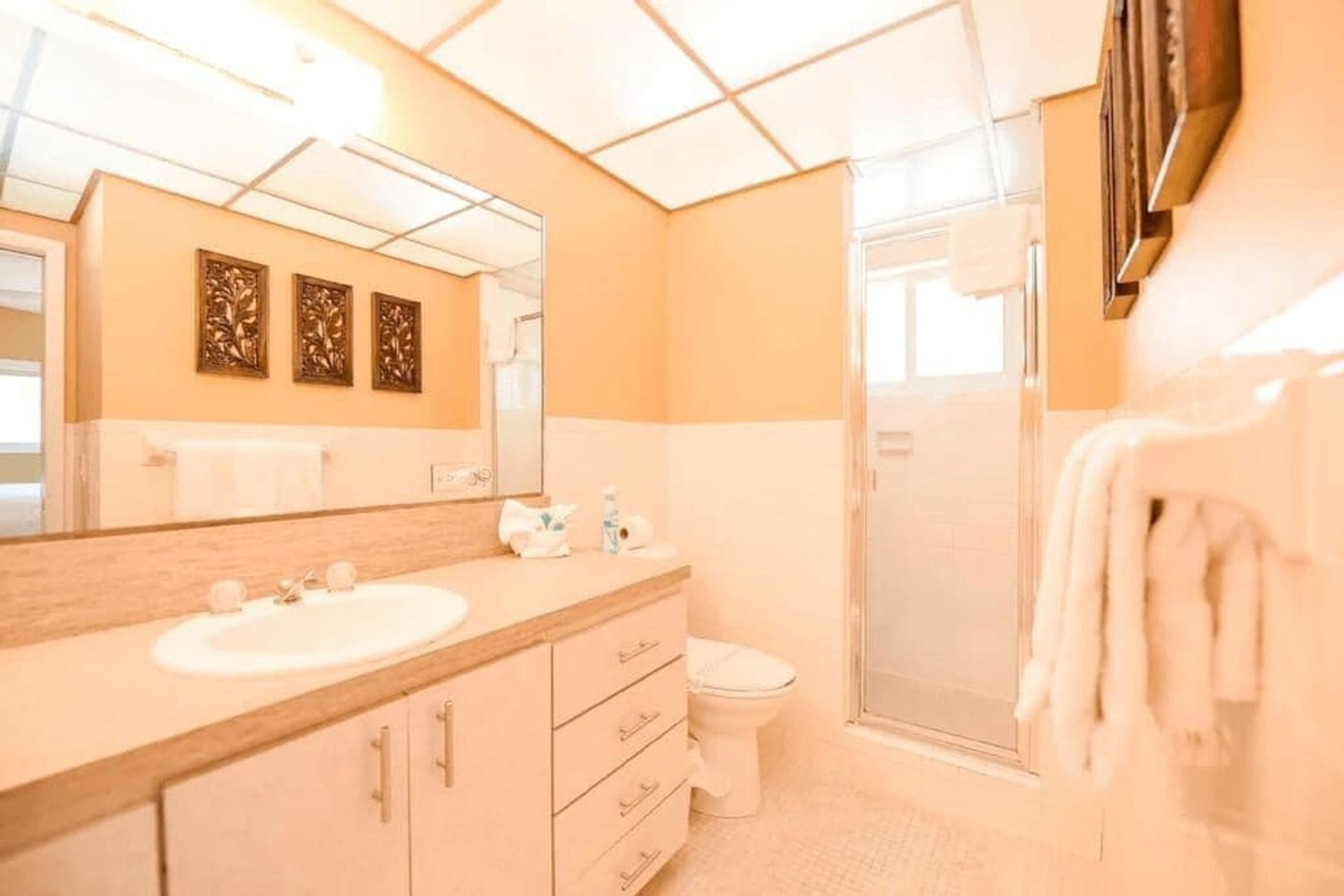 A bathroom with a sink, mirror, toilet, and shower.