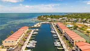 A marina with boats docked, a central waterway, and buildings with red roofs.
