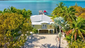 A beachfront property with a covered patio, a pool, and a view of the ocean. - Lime Key in Key Largo (Key Largo)