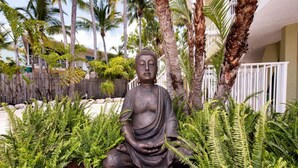 A Buddha statue in a garden with palm trees and ferns. - Lime Key in Key Largo (Key Largo)