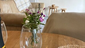 A cozy living room with a wooden table, a vase with flowers, a sofa, and a staircase in the background. - Farmhouse Annex in Saint Ishmael s (Haverfordwest)