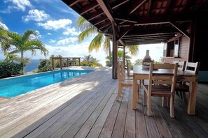 A wooden deck with a pool and outdoor seating area.