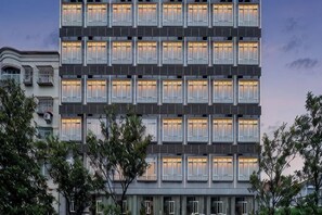 A multi-story building with a uniform facade, large windows, and a modern architectural style. - Yiju Qingyue Hotel (Xishui)